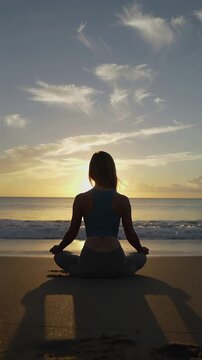 Silhouette of a person meditating on the beach at sunset, embracing peace and tranquility, vertical shot