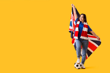 Female soccer fan with ball and UK flag on yellow background