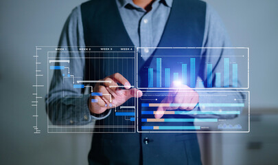 Businessman hand Project manager working and update tasks and Gantt chart scheduling virtual diagram.with smart phone, tablet and laptop in office.