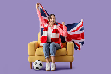 Female soccer fan with UK flag in armchair watching game on lilac background