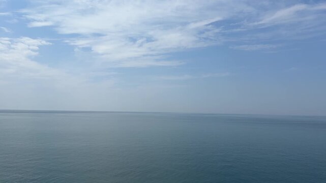 Calm sea, blue sky anf flying birds swallows.