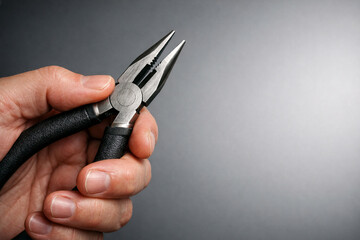 Obraz premium Close-up of person gripping combination pliers. Concept of manual labor and craftsmanship.