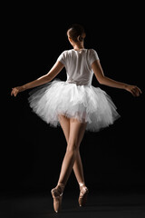 Fototapeta premium Young ballerina on dark background, back view