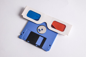 Blue retro  3.5 inch floppy disk with cardboard anaglyph 3D glasses on white background