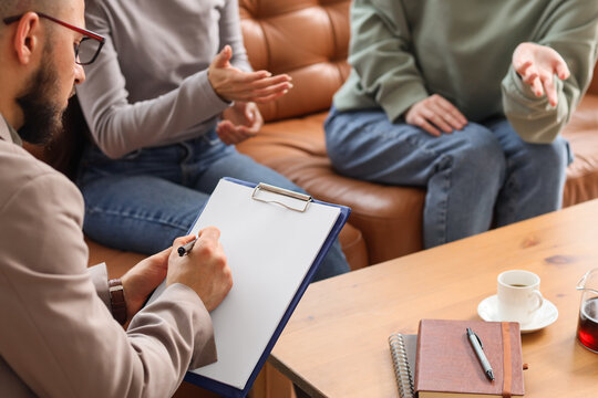 Male family mediator working with lesbian couple in office