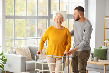Senior woman with walker and her grandson at home