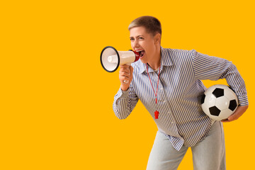 Female soccer fan with ball shouting into megaphone on yellow background