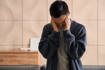 Obraz premium Sad young Asian man at home