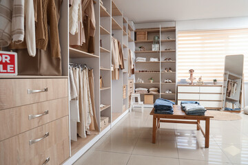 Interior of boutique with shelves, table and stylish clothes