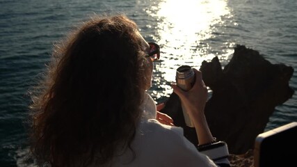 Traveling Woman Silhouette Drinks Thermos Watching Golden Ocean Sunset.