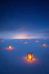 Glowing lanterns in snowy landscape at dusk create peaceful ambiance