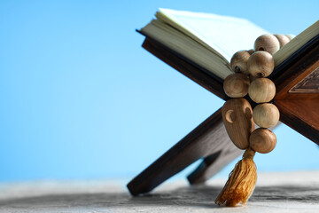 Rehal with Koran and Muslim beads on blue background. Ramadan celebration