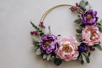Beautiful floral hoop frame with pink and purple peonies and gold rings on a white background