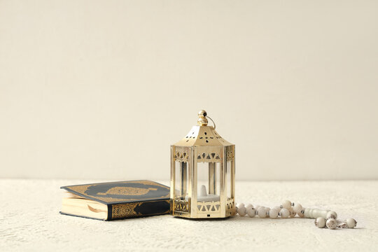 Koran, prayer beads for Ramadan and Muslim lantern on white grunge background