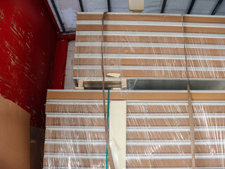 Stacked construction panels wrapped in plastic, ready for transport or storage