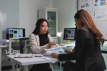 Businesswomen discussing financial data with charts