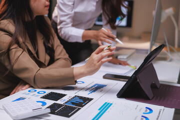 Businesswomen analyzing financial data and charts on paper
