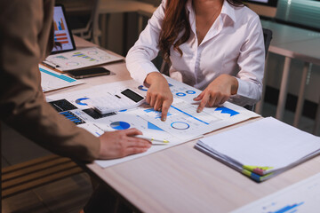 Businesswomen analyzing financial data, discussing market strategy