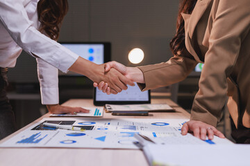 Business women shaking hands representing partnership agreement