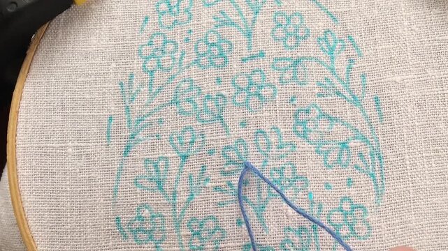 Close-up of a hand demonstrating fly stitch embroidery technique on fabric. Educational needlework video showing decorative hand embroidery, perfect for tutorials, DIY learning