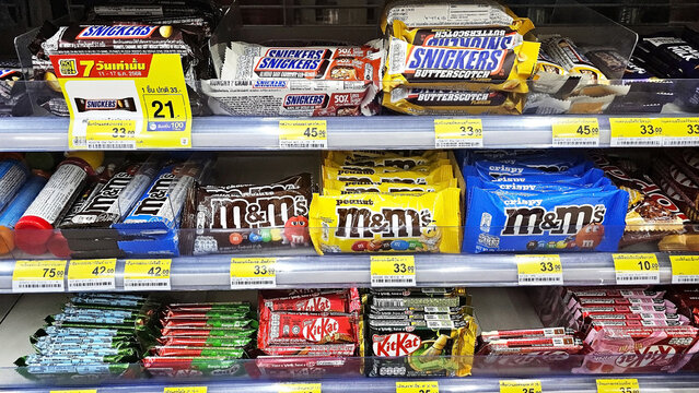 Aisle of Temptation: A meticulously organized display of assorted chocolate bars on store shelves, presenting a colorful panorama of consumer choices. Thailand, December 19, 2025