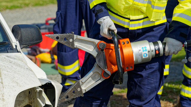 A firefighter pulls open a crashed car with a tool known as The Jaws Of Life