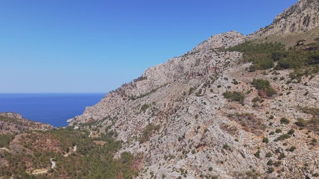 A drone captures the rugged landscape of Achata in Karpathos, revealing the beautiful beach in the background