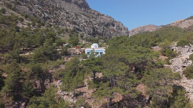 A drone pulls back from the chapel of Achata Beach in Karpathos, gradually revealing the stunning beach at the end.