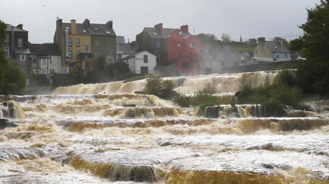 Calm river cascades by colorful town in Ennistymon, Ireland scenery
