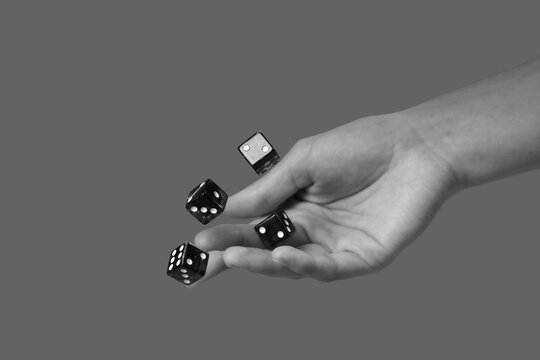 Hand throwing game dices on grey background