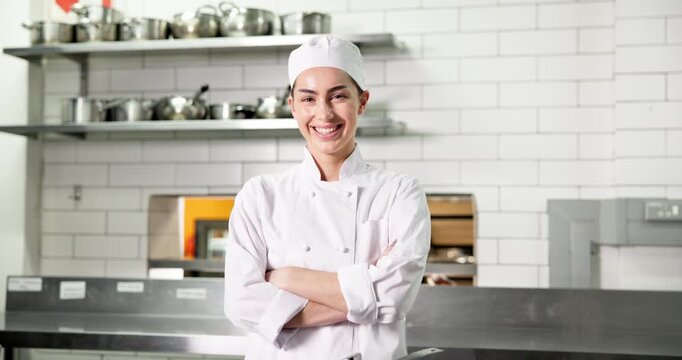 Face, chef and happy woman in kitchen for catering, gastronomy and pride in restaurant. Portrait, smile and culinary artist with arms crossed, professional cook and confidence for hospitality