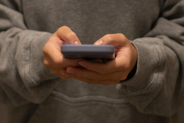 Closeup of a teenager using a mobile phone. Social media apps, screen time, short video streaming, and video games concepts.