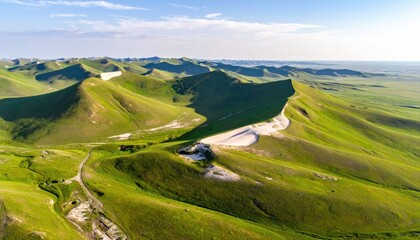 Naklejka premium Rolling green hills meeting a desert-like expanse under a bright sky