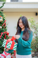 During Christmas time, a happy young woman enjoys a large Christmas gift.