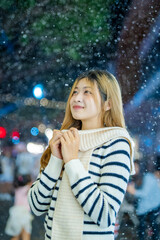  A young woman wearing a scarf and gloves is smiling outdoors in the snow during the winter.
