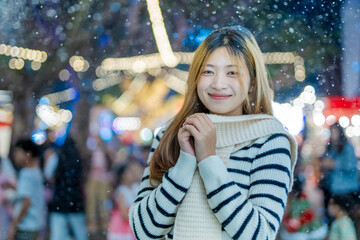  A young woman wearing a scarf and gloves is smiling outdoors in the snow during the winter.