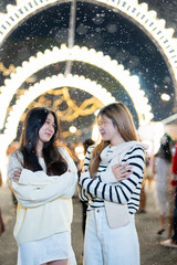  A young woman wearing a scarf and gloves is smiling outdoors in the snow during the winter.