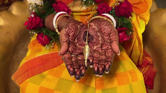 Indian bride with henna holding a kajal dani at a wedding in Kolkata, India