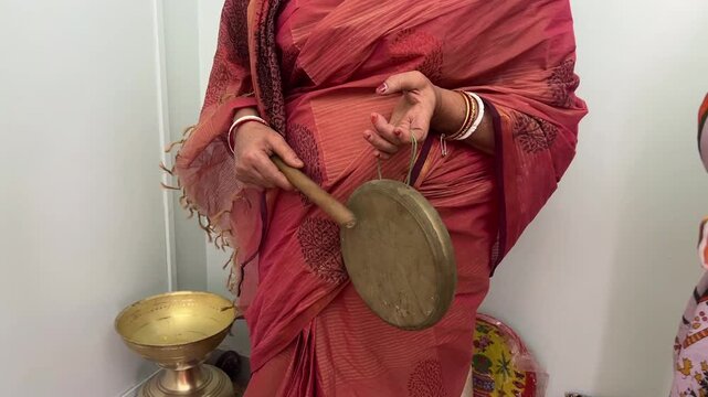Indian woman playing ghanta during a puja ceremony in India