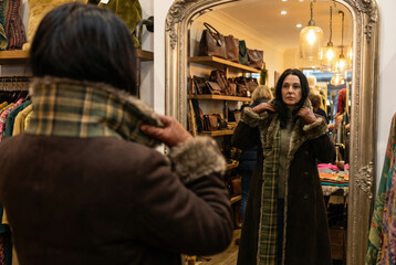Woman Trying on a Coat in a Boutique Mirror Reflection