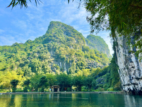 Majestic limestone karst mountains and bamboo trees reflected in the Ngo Dong river at Tam Coc - Bich Dong in the Trang An Landscape Complex - Ninh Hai, Hoa Lu, Ninh Binh, Vietnam on December 17, 2025