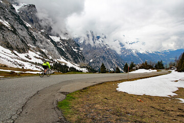 Cyclist heads down the Grosse Scheidegg pass towards Grindelwald in Swiss Alps