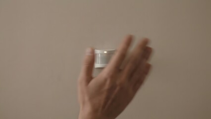 Hand Holding Small White Container Object.
