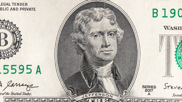 A detailed close-up image of multiple two-dollar bills featuring the portrait of Thomas Jefferson, arranged in an overlapping manner. Two american dollars banknote close up.