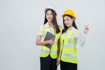 Asian female engineers collaborate on digital construction data, representing smart project coordination, technology-driven industry, women empowerment, and modern safety standards.
