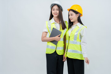 Two Asian women engineers use a tablet to review construction progress, highlighting smart monitoring systems, industry innovation, efficient teamwork, and digital transformation.