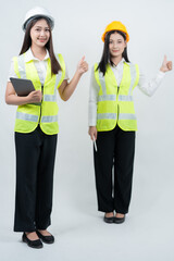 Vertical photo of two Asian female engineers reviewing construction data on a tablet, showcasing AI-assisted planning, smart industry systems, teamwork collaboration, and safety awareness.