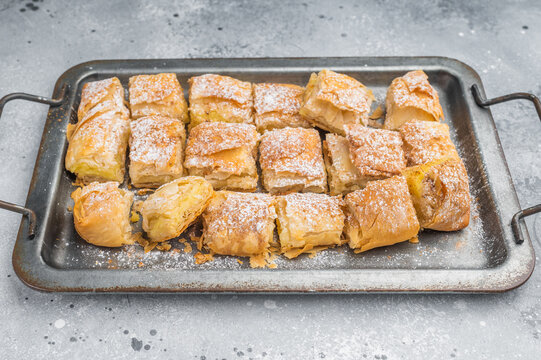 Custard pie made with flaky filo pastry also known as milk pie baked golden and sliced on metal tray top view