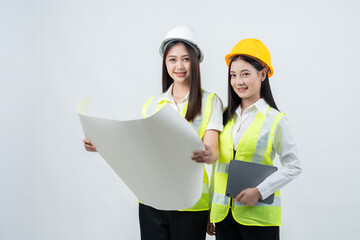 Asian female engineers discuss blueprints using digital tools, reflecting smart construction management, teamwork, and strategic planning that enhance the company's business operations.