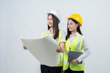 Two Asian female engineers analyze blueprints together, showcasing professional collaboration, smart construction planning, and innovation that enhances business performance within a company.
